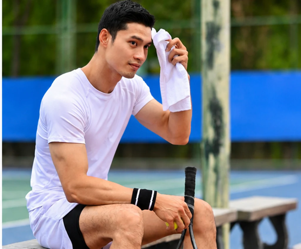 A tennis player wiping away sweat
